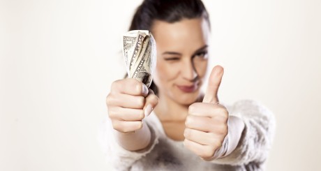 woman giving thumbs up holding money