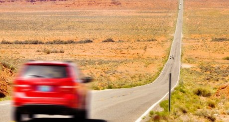 car driving down a highway in the desert