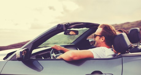 man in a convertible with the top down